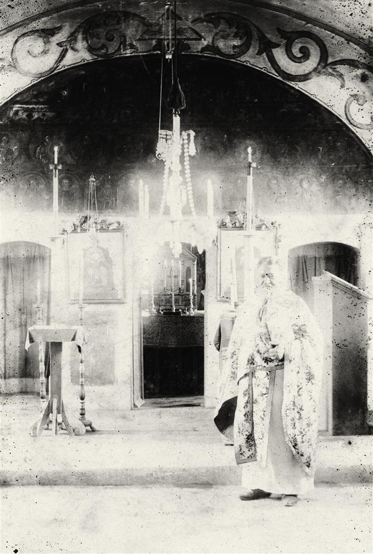 Preotul paroh Nicolae Cado, în haine liturgice, în faţa altarului bisericii ortodoxe din Pâclişa (1914).